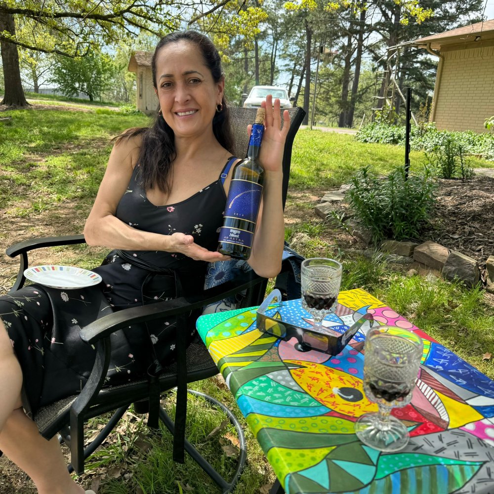 Luz sitting at a table with a glass of wine